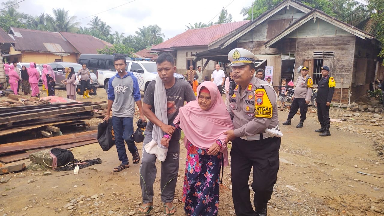 Serahkan Bansos ke Korban Banjir, Kasat Lantas Polres Palas Bantu Seorang Nenek